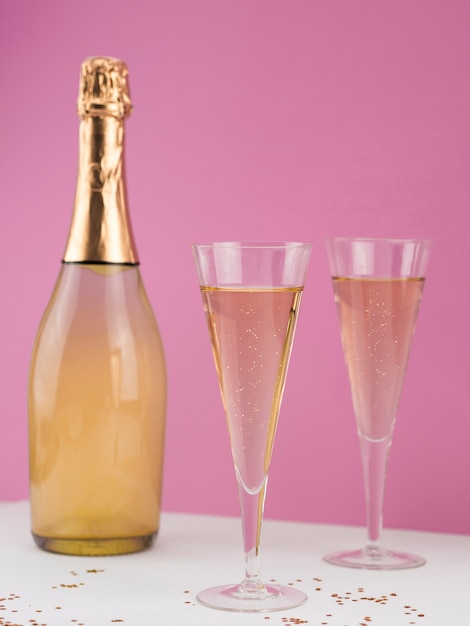 Front view of champagne bottle with filled glasses