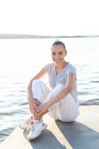 Front view charming woman posing on dock