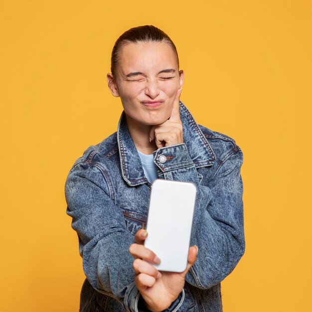 Front view of cheeky  woman holding smartphone