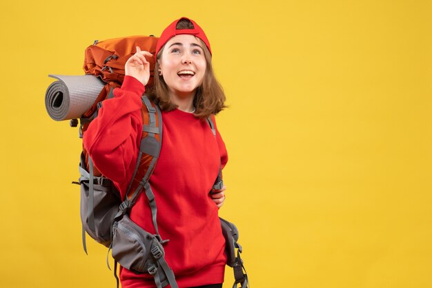 Front view cheerful female traveler with backpack looking up