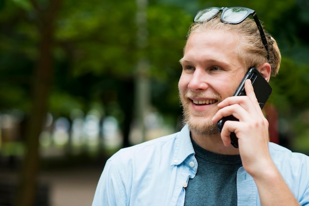 Front view of cheerful man talking on phone