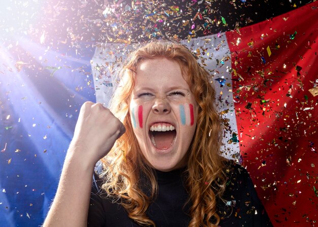 Front view of cheering woman with french flag and confetti