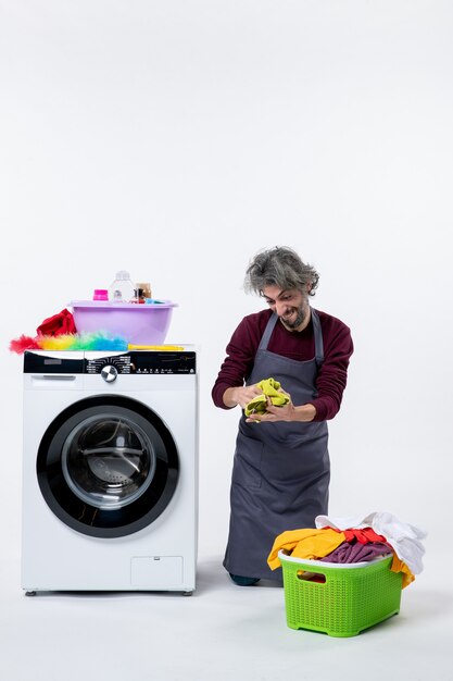 Front view cheery housekeeper man standing on knee holding cleaning cloth on white background