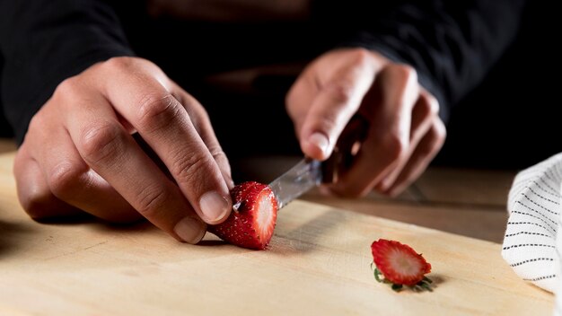 Front view of chef chopping strawberry