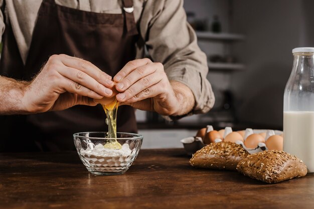 Front view chef cracking egg