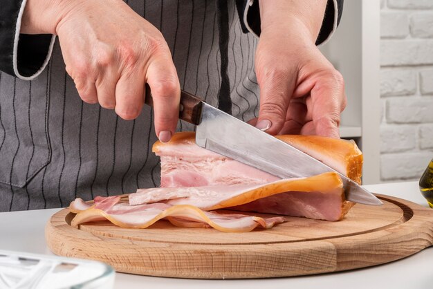 Front view of chef cutting bacon strips