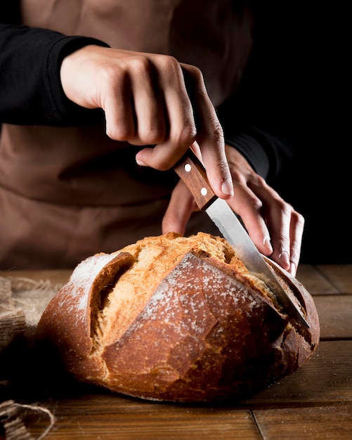 Front view of chef cutting delicious bread