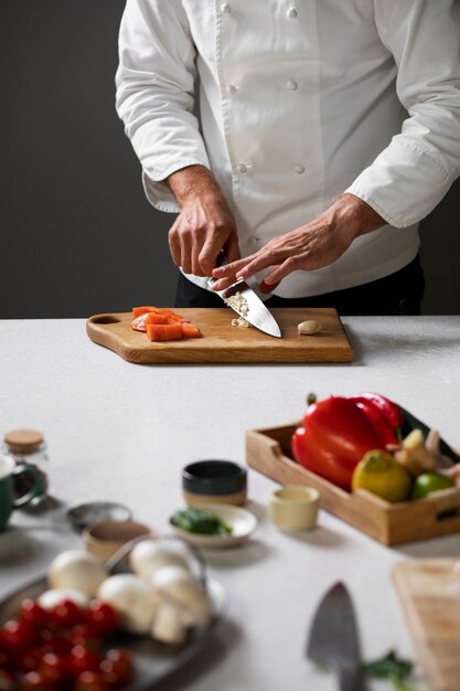 Front view chef cutting garlic