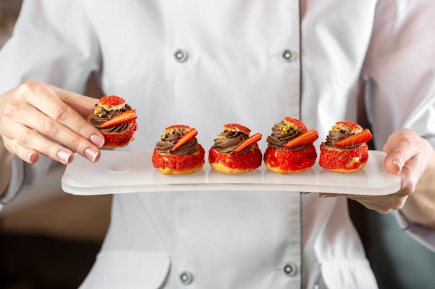 Free photo front view of chef holding a delciious food plate