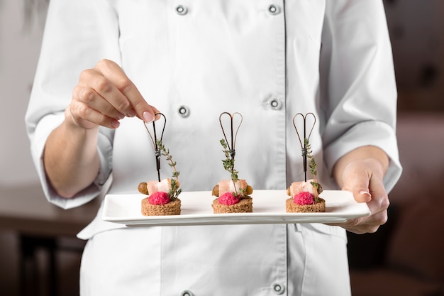 Free photo front view of chef holding a food plate
