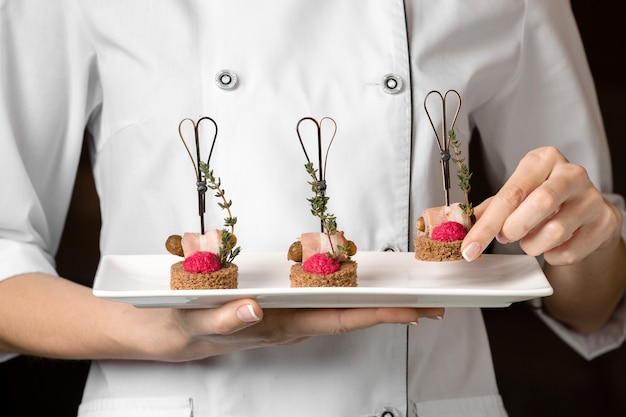 Front view of chef holding a food plate