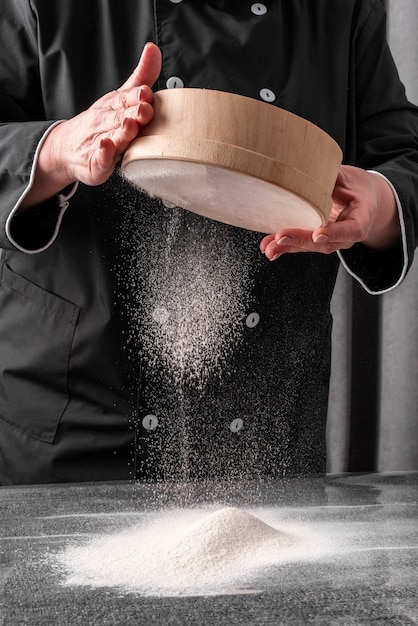 小麦粉をふるうシェフの正面図