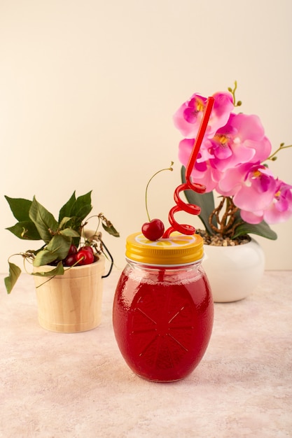 Вид спереди вишневый коктейль красный с соломой внутри маленькой банки свежее охлаждение на розовом