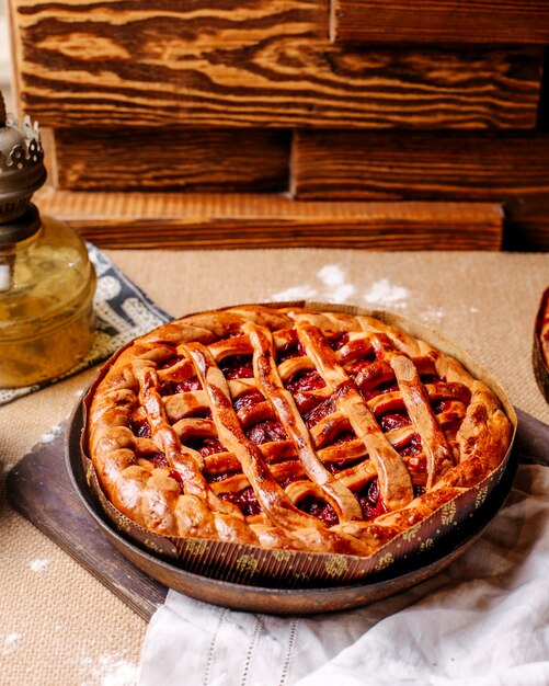 Front view cherry pie inside round pan on the bright floor