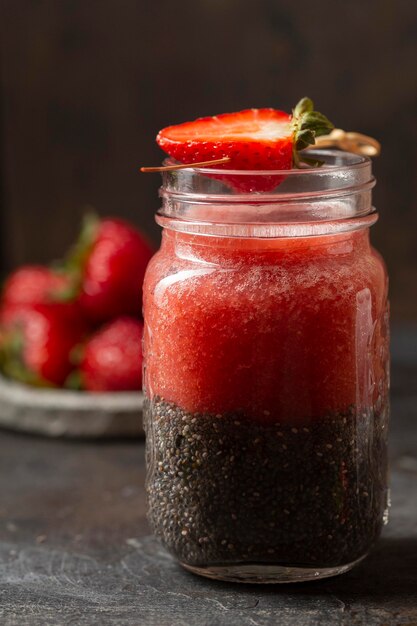 Front view chia seeds and strawberry puree in jar