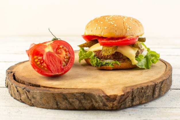 A front view chicken burger with cheese and green salad on the wooden desk and sandwich fast-food meal food