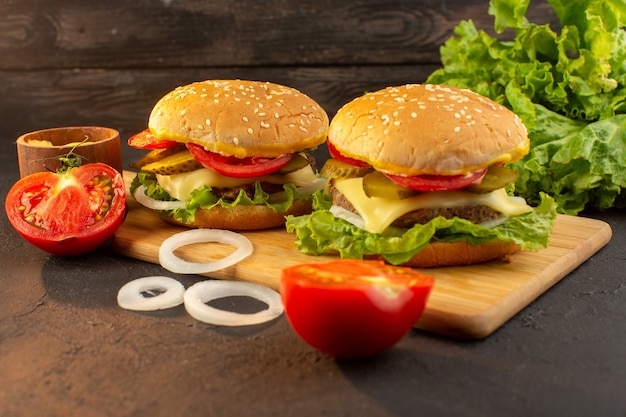 A front view chicken burger with cheese and green salad on the wooden desk and sandwich fast-food meal vegetables