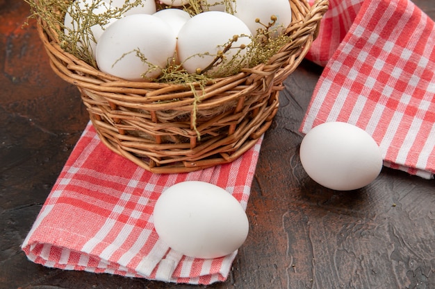 Front view chicken eggs inside basket on a dark surface