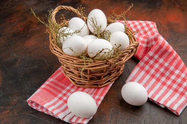 Front view chicken eggs inside basket on dark surface