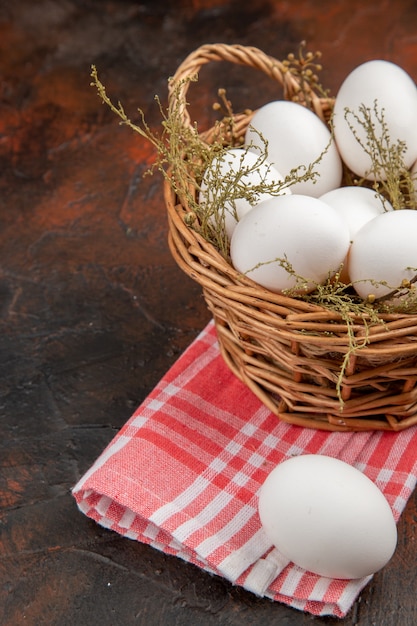 Front view chicken eggs inside basket on dark surface