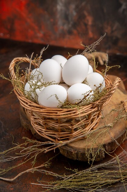 Front view chicken eggs inside basket on dark surface