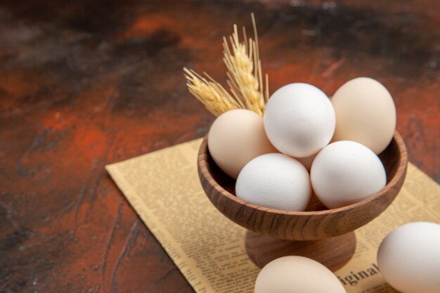 Front view chicken eggs inside plate on dark surface