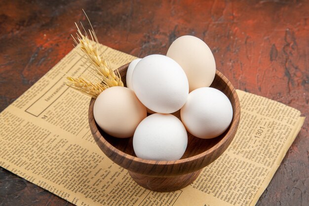 Front view chicken eggs inside plate on dark surface