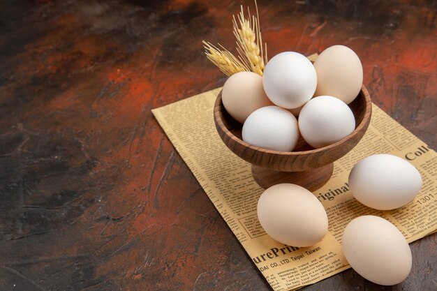 Front view chicken eggs inside plate on dark surface