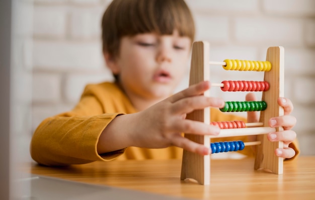 Front view of child at desk using abacus