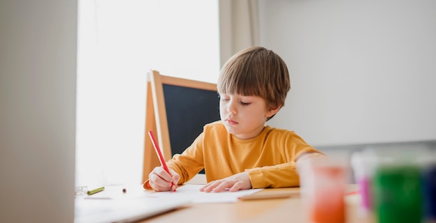 Front view of child drawing at desk