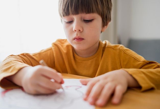 Front view of child drawing at home