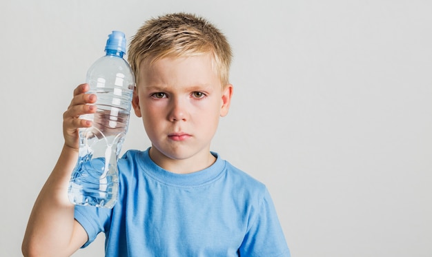 Front view child holding a water bottle