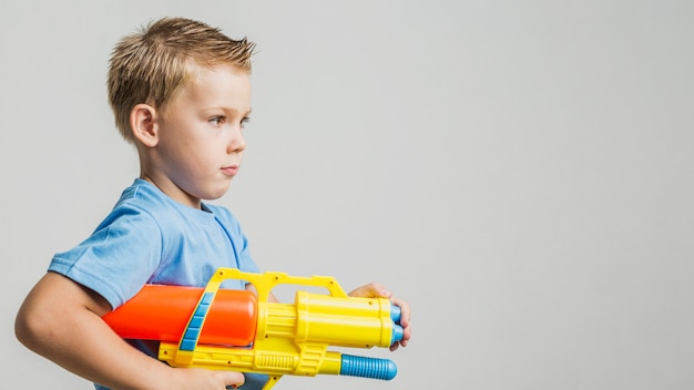 Front view child holding a water gun