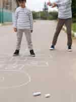 Free photo front view child playing hopscotch