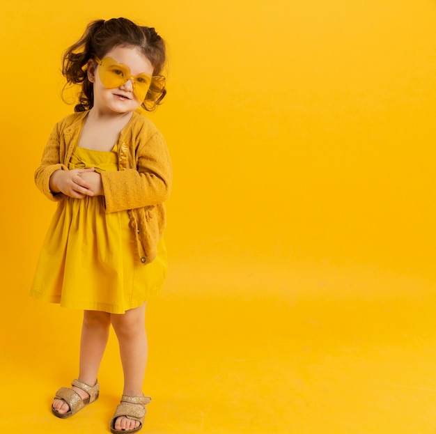 Free photo front view of child posing while wearing sunglasses