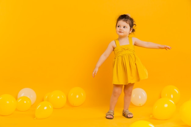Вид спереди ребенка позирует с воздушными шарами и копией пространства