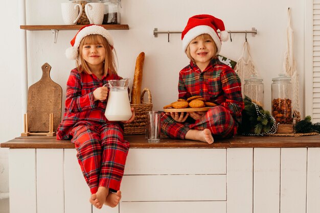 Front view children eating christmas cookies