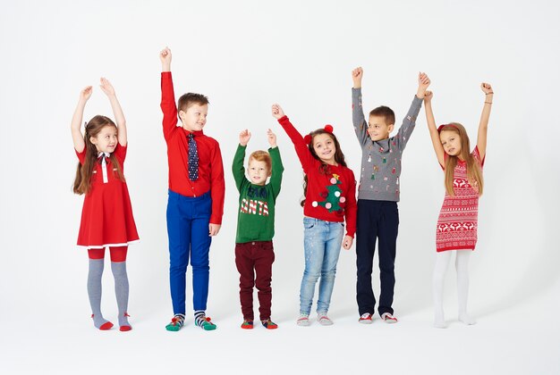 Front view of children hands up standing in a row