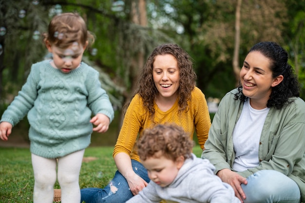 Front view of children outdoors in the park with lgbt mothers