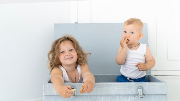 Front view children sitting in a box