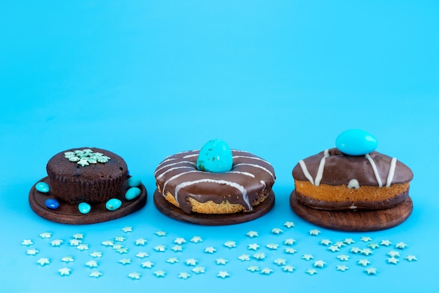Foto gratuita una vista frontale brownies al cioccolato con torte e ciambelle su blu, colore biscotto torta di zucchero