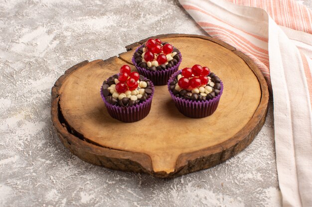 Front view of chocolate brownies with cranberries and cream