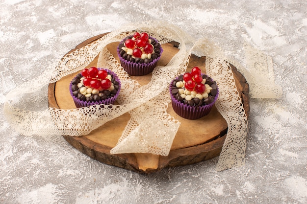 Front view of chocolate brownies with cranberries on the light surface