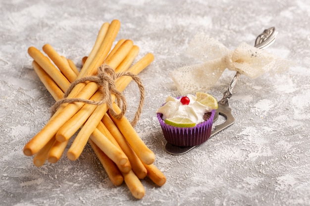 Front view of chocolate brownies with cream and lemon slices along with stick crackers