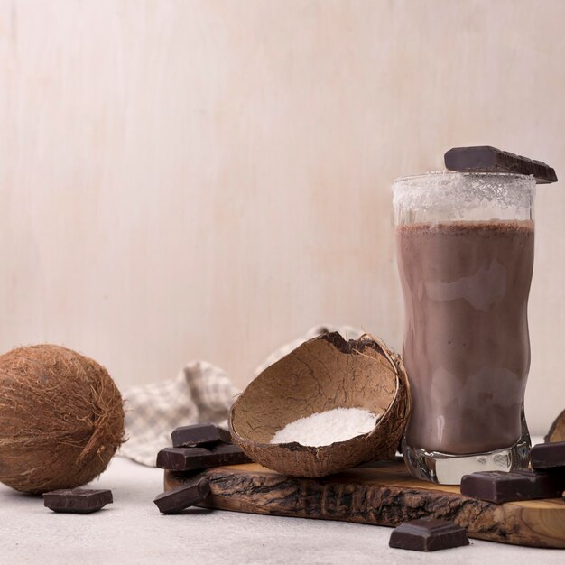 Front view of chocolate and coconut milkshake glass with copy space