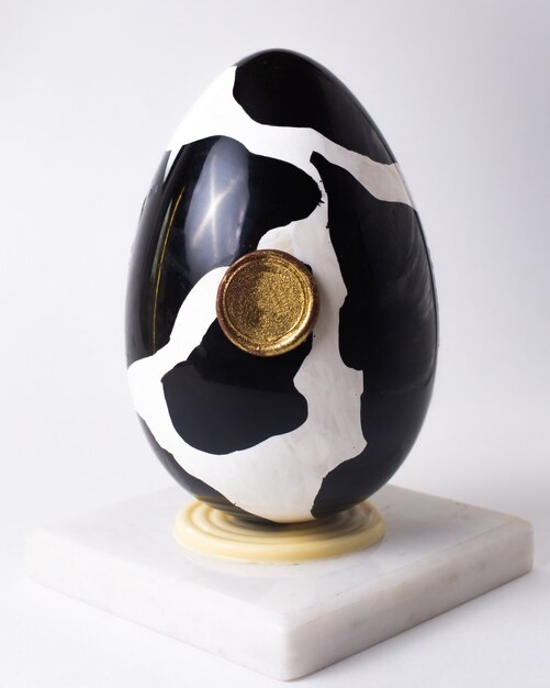 Front view chocolate egg in cow coloring black and white on stand
