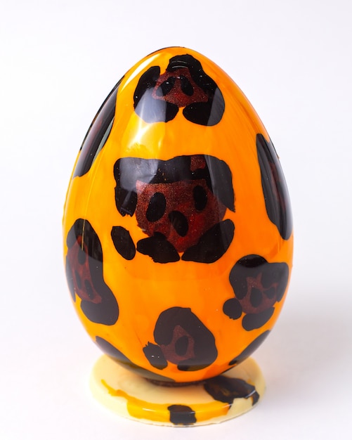 Free photo front view chocolate egg in leopard coloring on stand