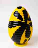 Free photo front view chocolate egg yellow with black on stand