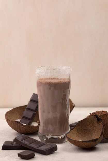 Front view of chocolate milkshake glass with coconut and copy space