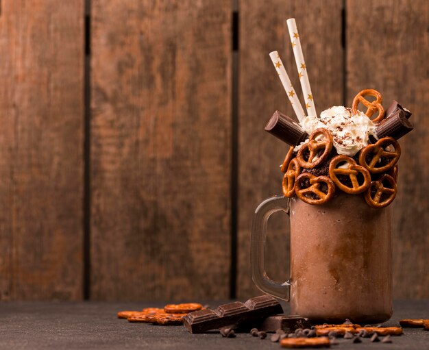 Front view of chocolate milkshake with pretzels and copy space